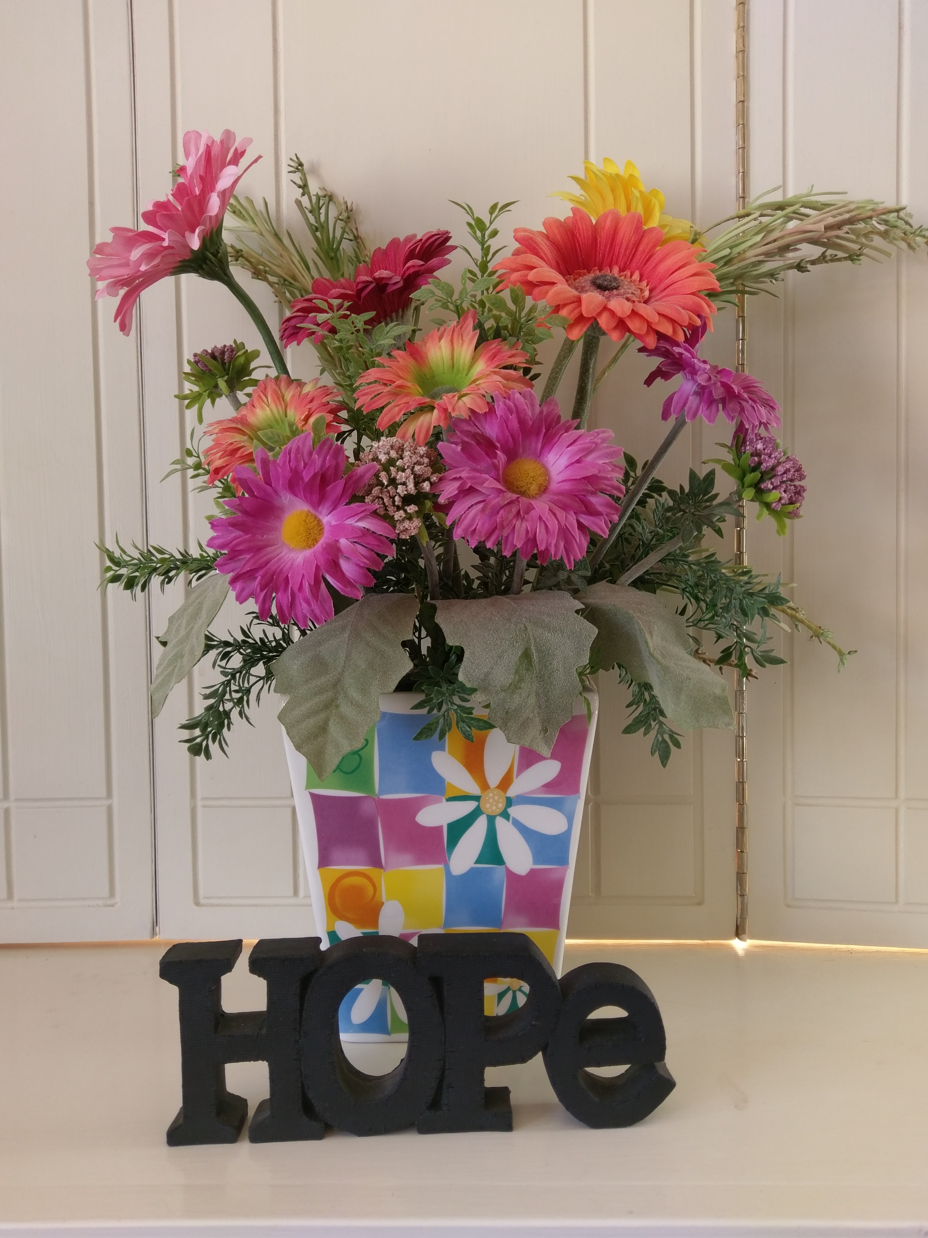 A bright, colorful arrangement of flowers, with the word HOPE at it's base.