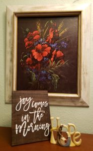 A beautiful picture of red poppies with "Joy comes in the morning. And a figurine of hope with Mary, Joseph and Jesus.