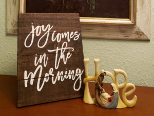 Hope brings joy. The picture has a plaque which says, "Joy Comes in the Morning." with another plaque which says "Hope."