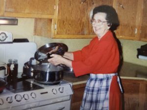 Mom cooking at her stove with her apron on.