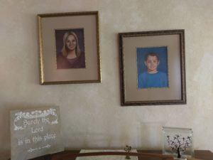 Two portraits above a piano.