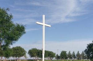 A beautiful white cross in a local cemetery represents our greatest help: Jesus Christ